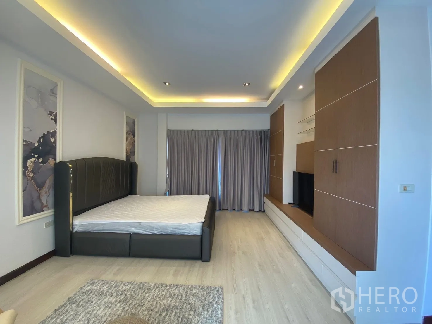 Detached House for rent in Suan Luang, Bangkok - Primary bedroom with built-in storage, cove lighting and a large bed.