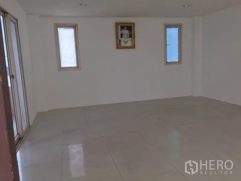 Factory for rent in Lam Luk Ka, Pathum Thani - Empty office room with tiled floor and two narrow windows allowing natural light.