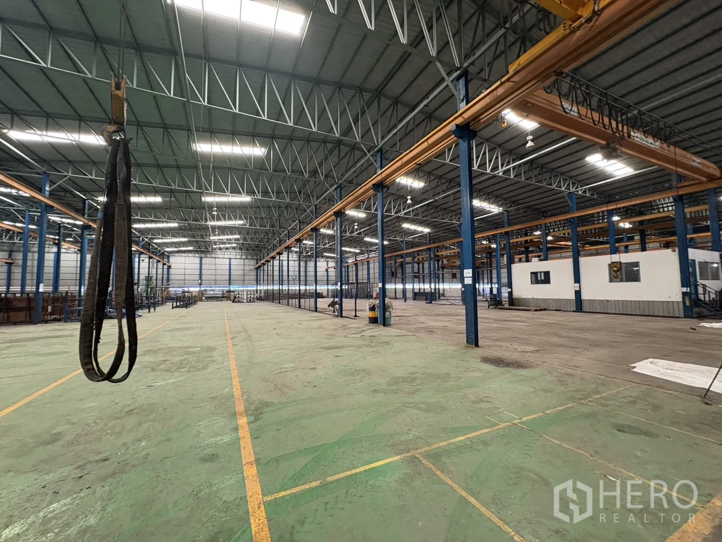 Factory for rent in Phra Pradaeng, Samut Prakan - Aisle inside the factory with multiple overhead cranes and skylights.