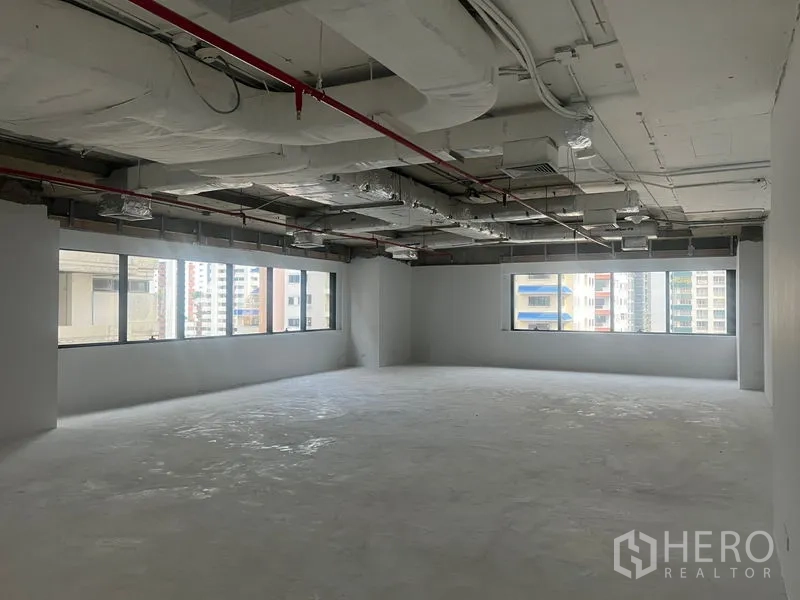 Office Space for rent - Large white-walled office floor with panoramic windows overlooking nearby towers.