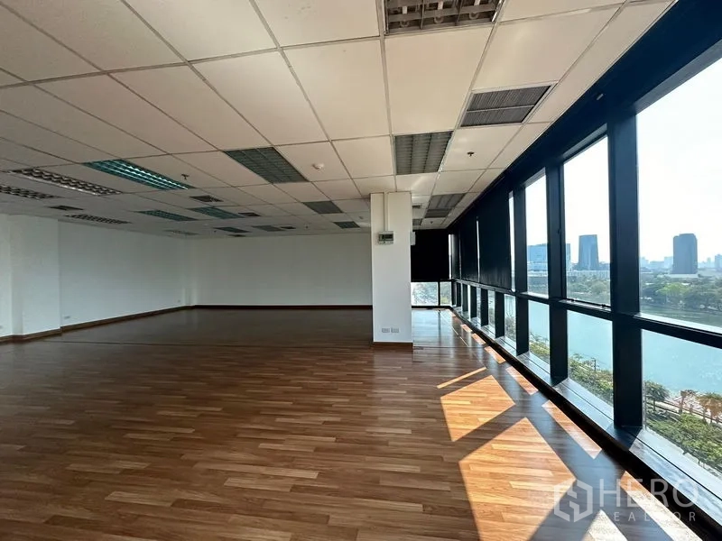 Office Space for rent in Watthana, Bangkok - Corner workspace with full-height windows offering city and lake views.