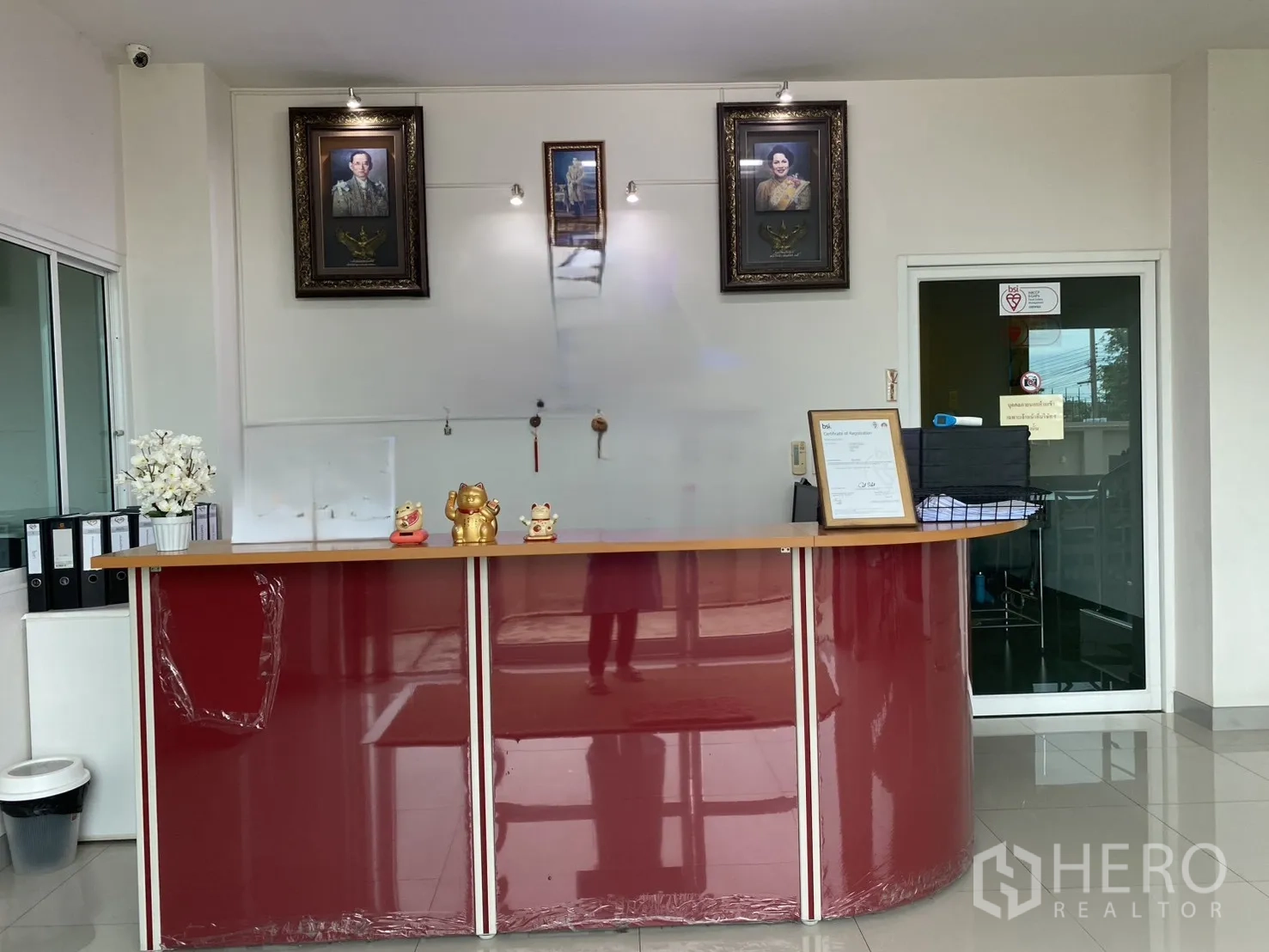 Factory for sale in Khlong Luang, Pathum Thani - Reception area with a curved red counter and glossy tiled floor.