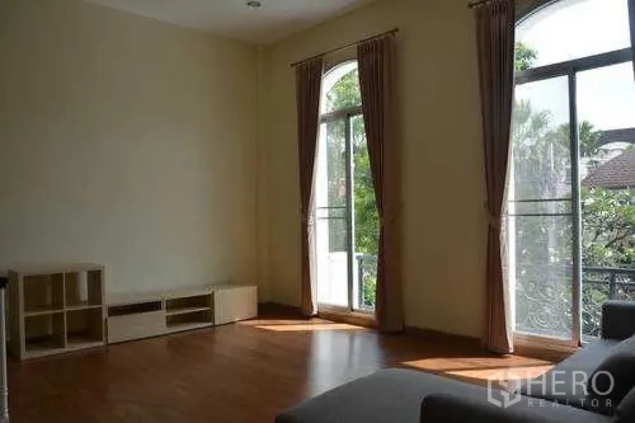Home Office for rent in Wang Thonglang, Bangkok - Sunlit living area with arched floor-to-ceiling windows, balcony rail and garden view in Wang Thonglang.