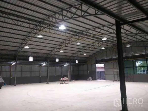 Warehouse for rent in Khlong Sam Wa, Bangkok - Interior showing steel truss roof, large industrial doors and well‑lit open storage space.