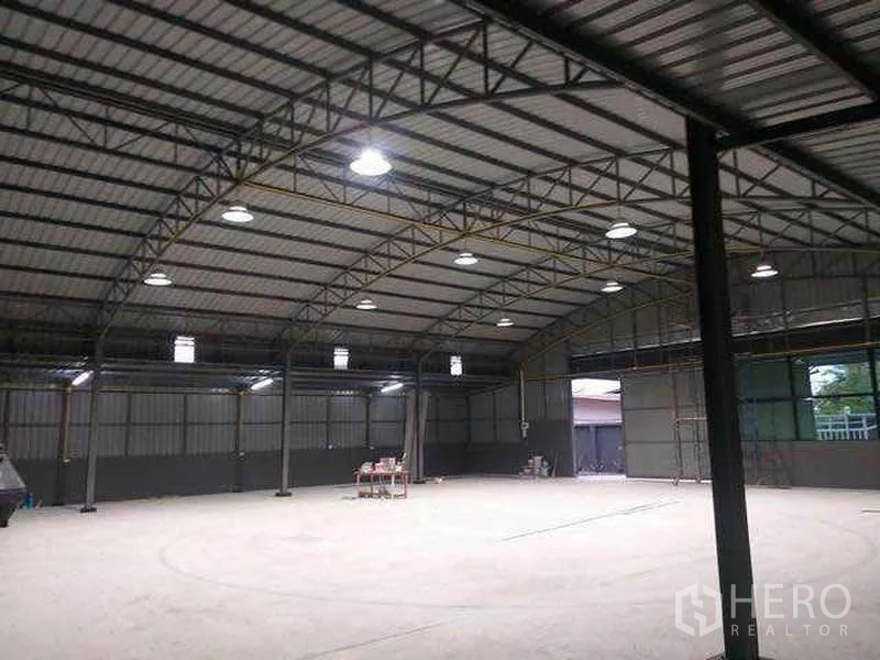 Warehouse for rent in Khlong Sam Wa, Bangkok - Interior showing steel truss roof, large industrial doors and well‑lit open storage space.