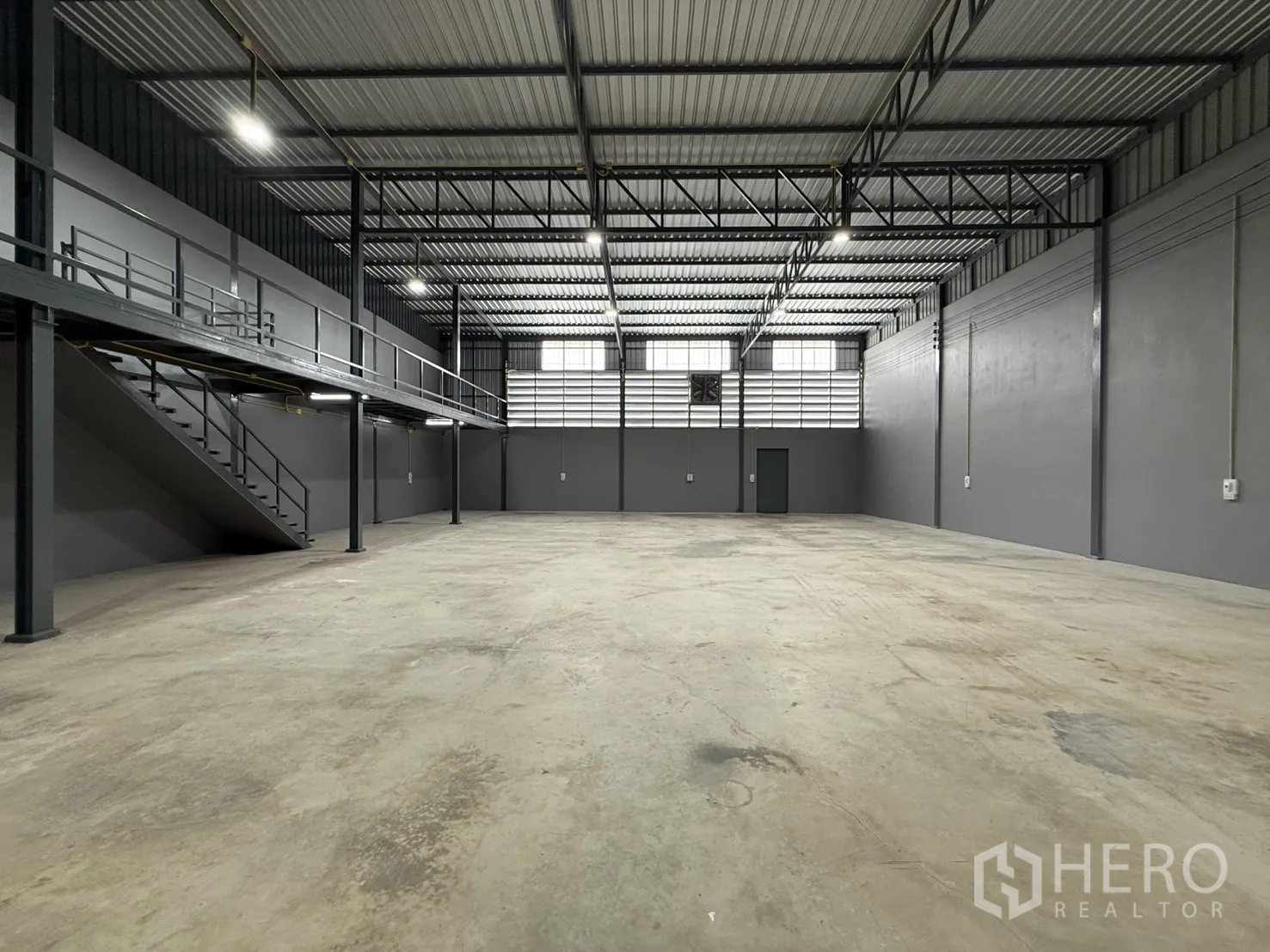 Warehouse for rent in Lam Luk Ka, Pathum Thani - Large warehouse hall with high ceiling, lighting, and concrete floor.