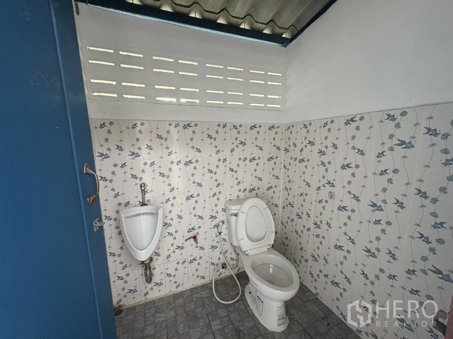 货栈 出租在Bang Phli, Samut Prakan - 卫生间内的坐便器与小便斗，花纹墙砖与通风砖