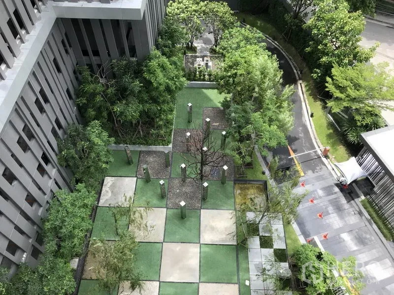 Condominium for rent or sale in Khlong Toei, Bangkok - Landscaped courtyard garden with checkerboard paving and mature trees.