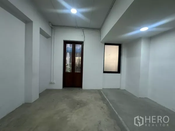 Home Office for rent in Pathum Wan, Bangkok - Room with concrete floor, white walls, wooden-framed door and a side window.