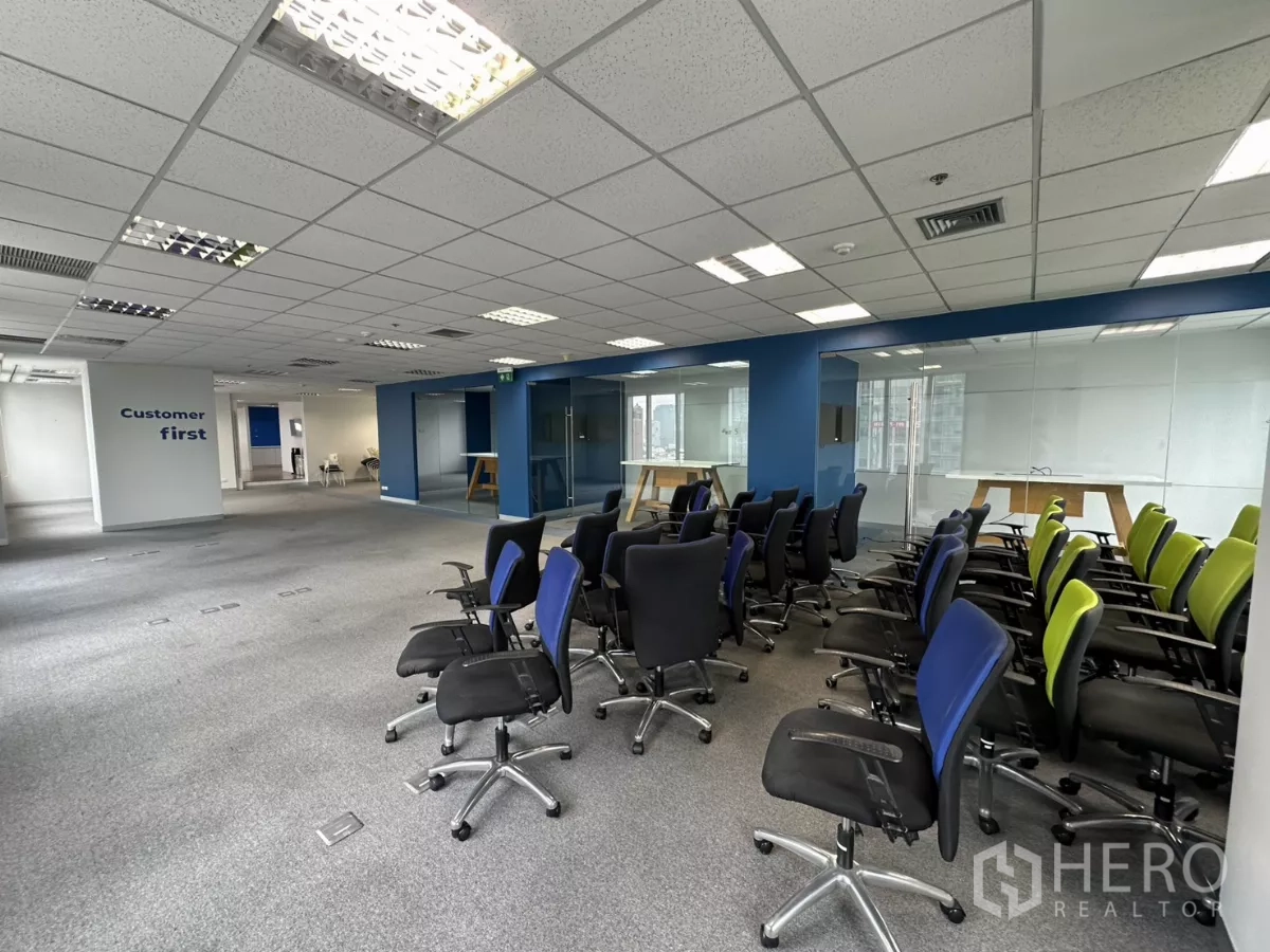 Office Space for rent in Watthana, Bangkok - Open office with training chairs and signage, adjacent to glass rooms.