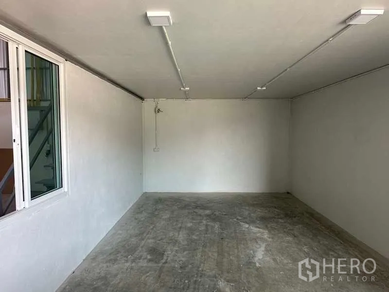 Warehouse for rent in Bang Bua Thong, Nonthaburi - Empty office room with lighting and a window overlooking the warehouse floor.