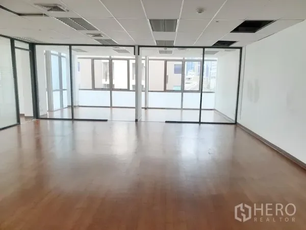 Office Space for rent in Khlong Toei, Bangkok - Spacious office interior featuring glass sliding partitions, ceiling lights and vents, and natural light from multiple windows.