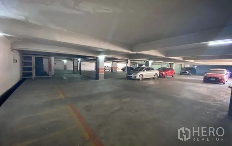 Warehouse for rent in Bang Phli, Samut Prakan - Covered parking garage with marked bays and several cars under concrete beams.