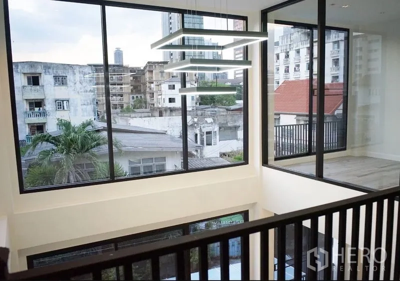 สำนักงานที่บ้าน ให้เช่าหรือขายในWatthana, Bangkok - มุมมองจากชั้นลอย เห็นหน้าต่างบานใหญ่ โคมไฟแขวนสมัยใหม่ และวิวชุมชน