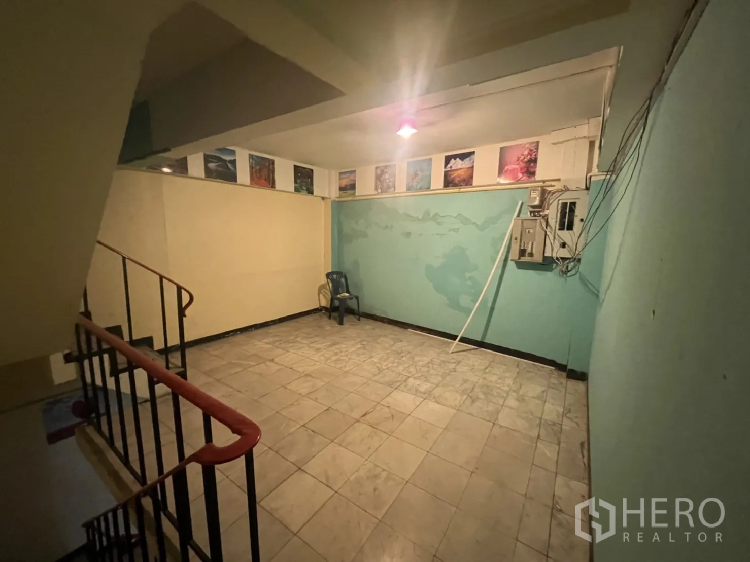 Shophouse for rent in Watthana, Bangkok - Stair landing with tiled floor, warm lighting and electrical control panels.