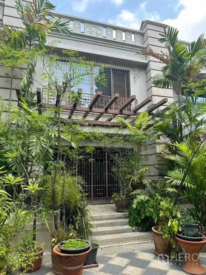 Townhouse for rent in Khlong Toei, Bangkok - Townhouse facade in Khlong Toei, Bangkok with lush tropical garden, balcony pergola and gated entrance.