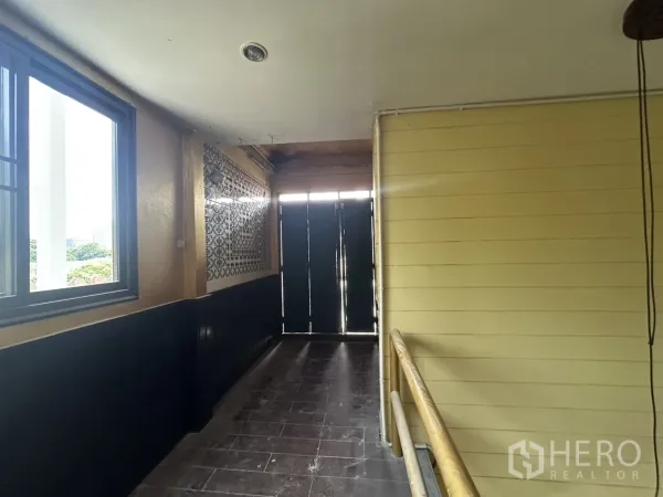 Retail Space for rent in Bang Rak, Bangkok - Hallway with window, patterned wall tiles and double doors inside the retail unit.