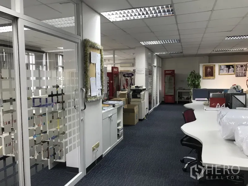 Office Space for rent in Khlong Toei, Bangkok - Glass‑partitioned meeting rooms along a corridor with built‑in cabinets and fluorescent lighting.