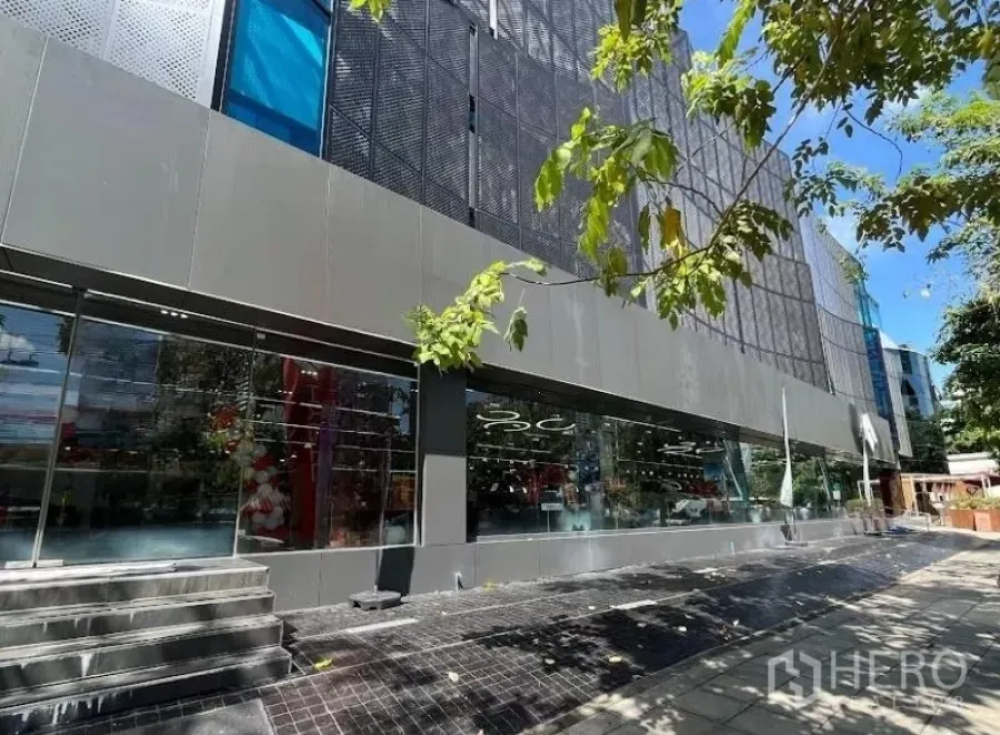 Showroom for rent in Bang Rak, Bangkok - Street-level glass-front showroom exterior in the Silom–Sathorn CBD with wide windows and a shaded sidewalk.