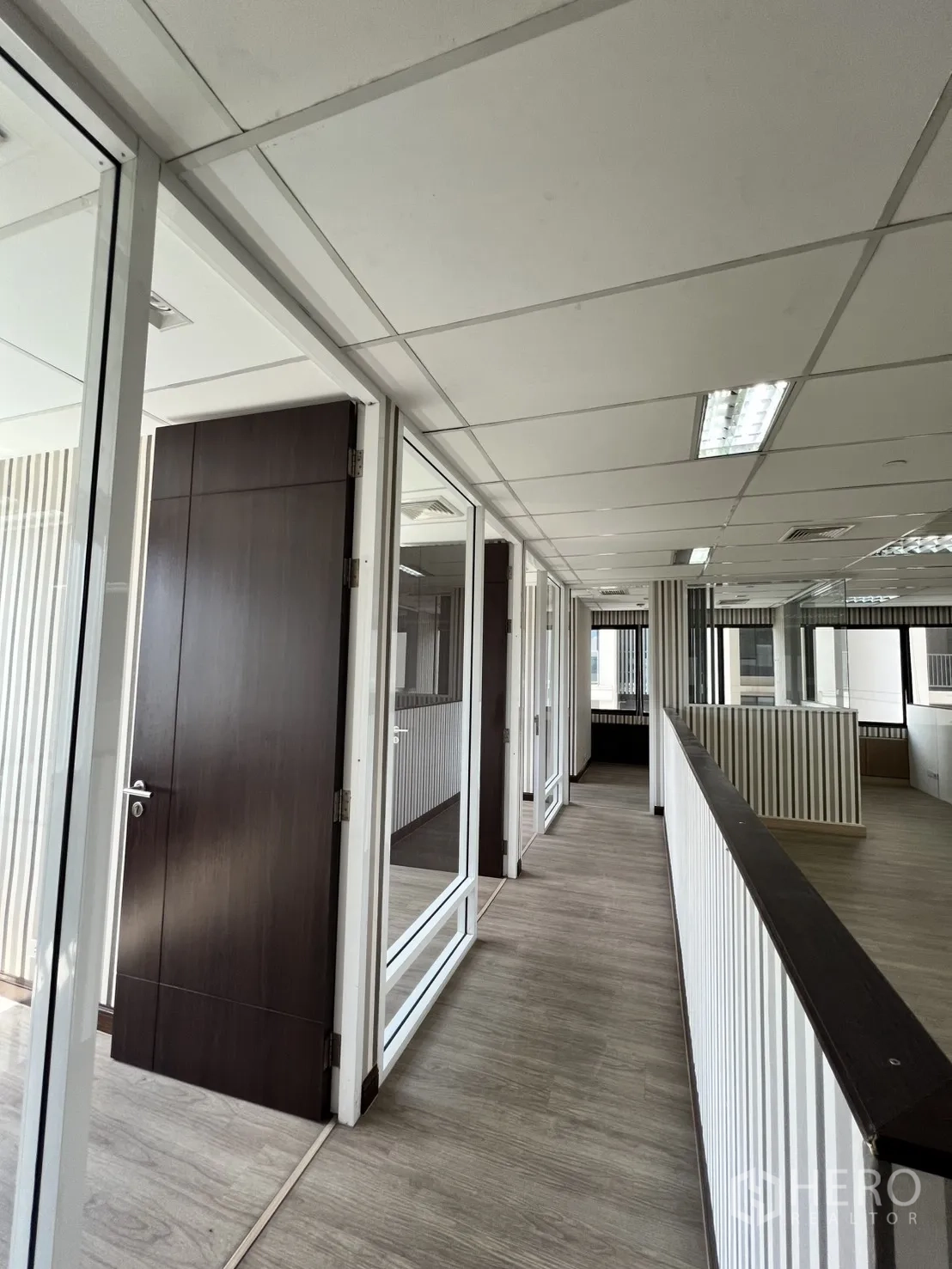 Office Space for rent in Watthana, Bangkok - Corridor lined with glass-partitioned private offices.