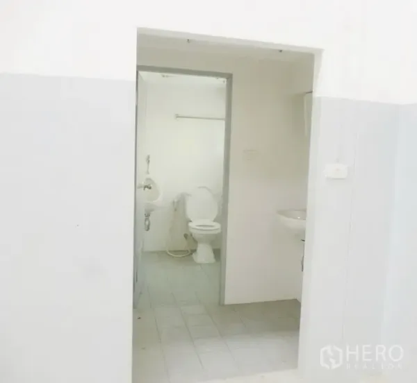 Factory for rent or sale in Pathum Thani - Clean restroom inside the facility with toilet, urinal and washbasin on tiled flooring.