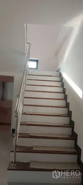 Factory for rent or sale in Sai Noi, Nonthaburi - Interior staircase with stainless-steel handrail leading up to the office level.