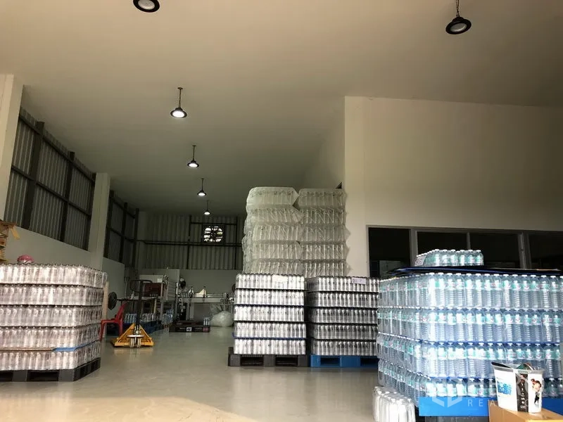Factory for rent or sale in Wang Noi, Phra Nakhon Si Ayutthaya - High-ceiling production hall with stacked bottled products and overhead lighting.
