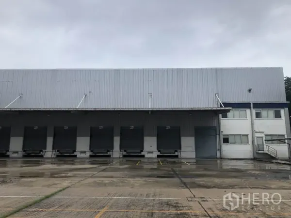 Factory for rent in Phra Nakhon Si Ayutthaya - Row of loading docks with roller shutter doors and an attached office block at the factory.