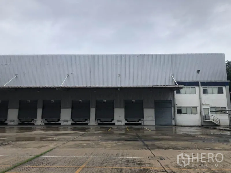 Factory for rent in Phra Nakhon Si Ayutthaya - Row of loading docks with roller shutter doors and an attached office block at the factory.