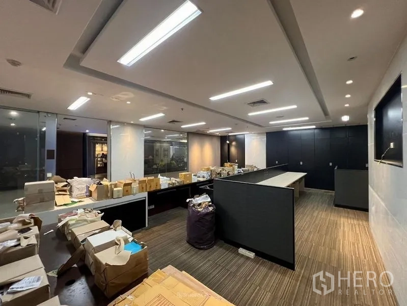 Retail Space for rent - Open-plan retail or office floor with LED strip lighting, glass partitions, carpet tiles and a built-in counter.