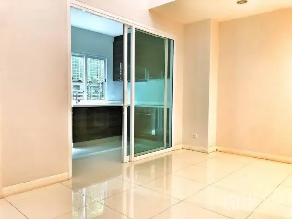 Townhouse for rent in Watthana, Bangkok - Dining space with sliding glass doors opening to the kitchen.