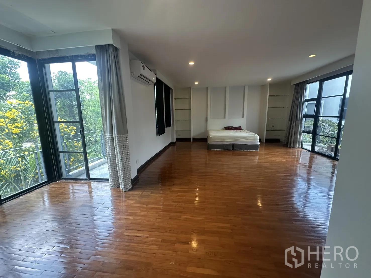 Detached House for rent in Watthana, Bangkok - Corner bedroom with wraparound windows and green views.