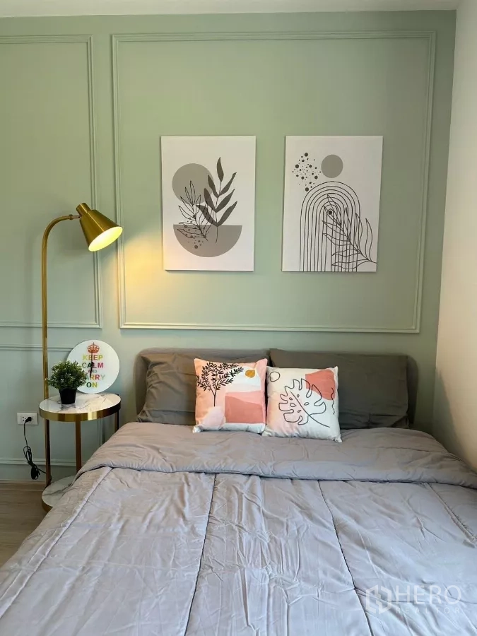 Townhouse for rent in Bang Phli, Samut Prakan - Second bedroom bed with decorative pillows and a green feature wall.