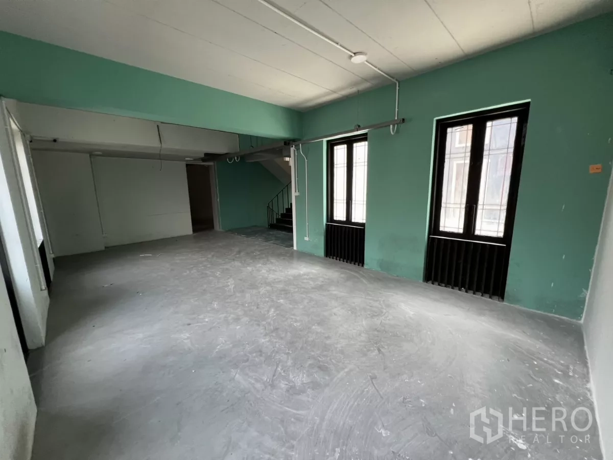 Home Office for rent in Pathum Wan, Bangkok - Large upper-floor workspace with mint walls, windows and stair access.