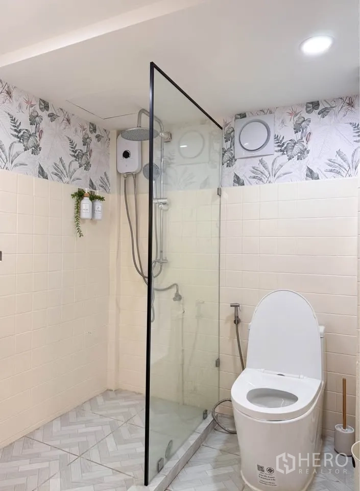 Detached House for rent in Huai Khwang, Bangkok - Bathroom with glass-enclosed shower, rain head and modern toilet.