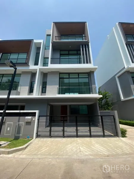 联排别墅 出租在Saphan Sung, Bangkok - Saphan Sung 区现代多层联排别墅外立面，带阳台、整面落地窗和入户车位。