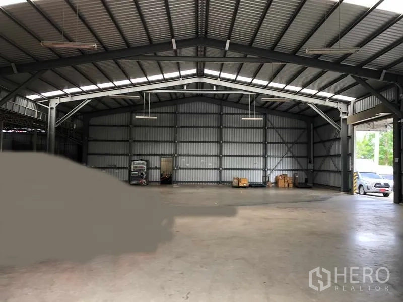 Warehouse for rent in Pak Kret, Nonthaburi - Open-span warehouse hall with steel trusses, roller-door access and clear floor space for storage.