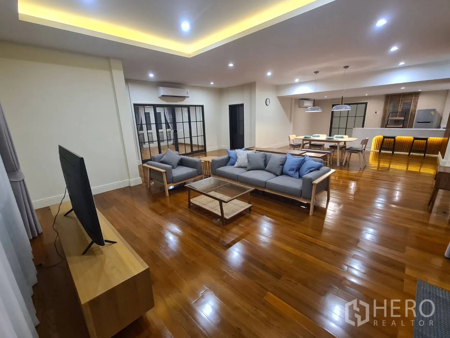 Detached House for rent in Khlong Toei, Bangkok - Open-plan living, dining and kitchen with recessed lighting and glossy timber floors.