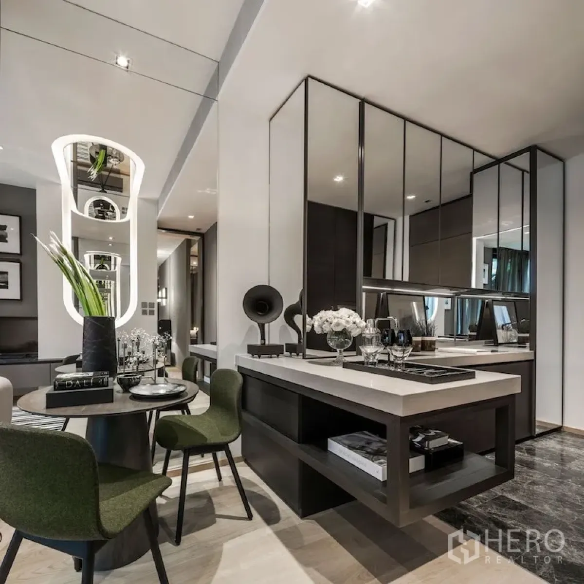 Condominium for sale in Pathum Wan, Bangkok - Modern open-plan living and dining area with mirrored cabinets, green chairs, and a sleek island counter.