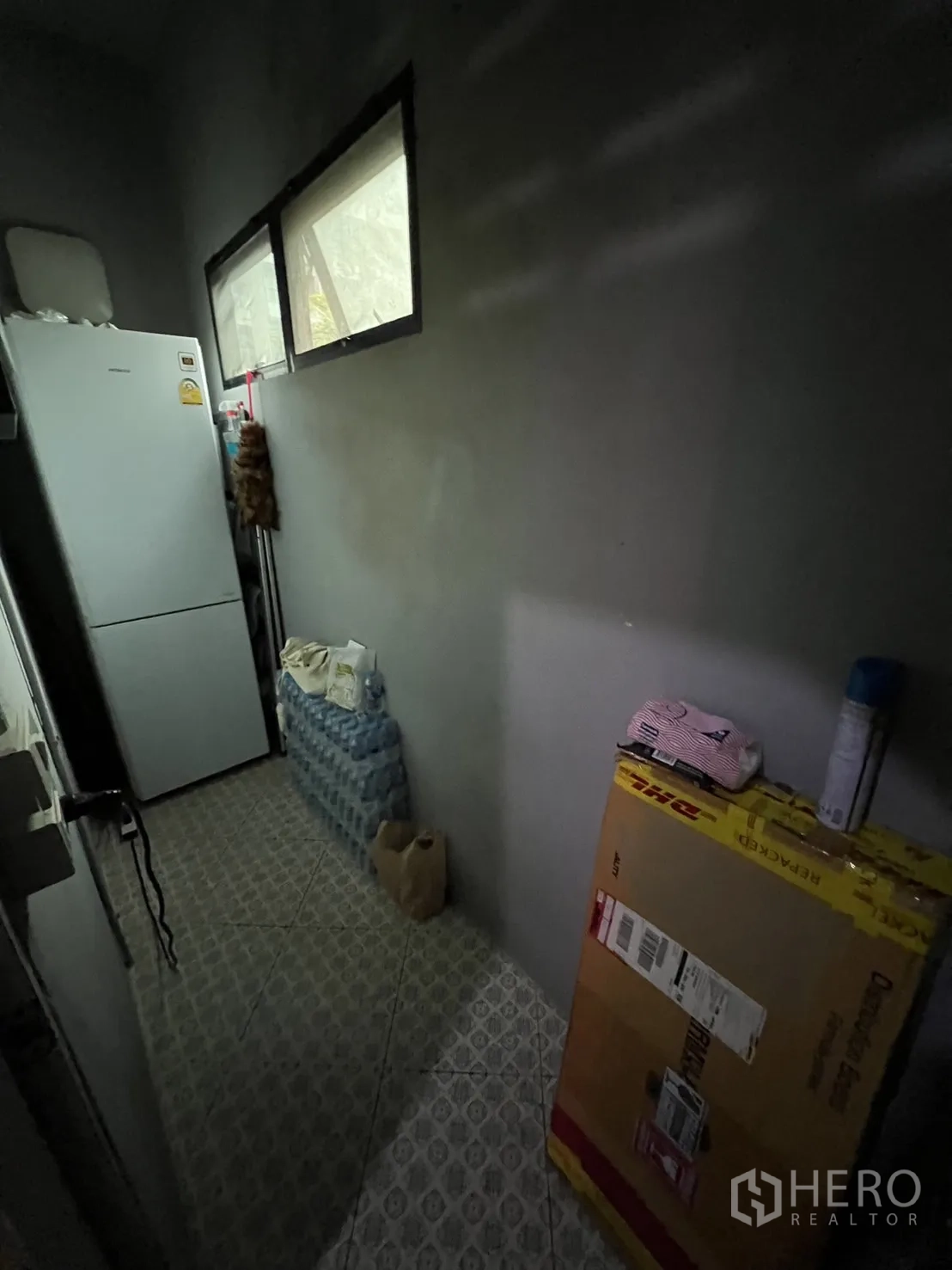 Shophouse for rent or sale in Watthana, Bangkok - Narrow pantry or storage corridor with refrigerator, supplies and tiled floor.