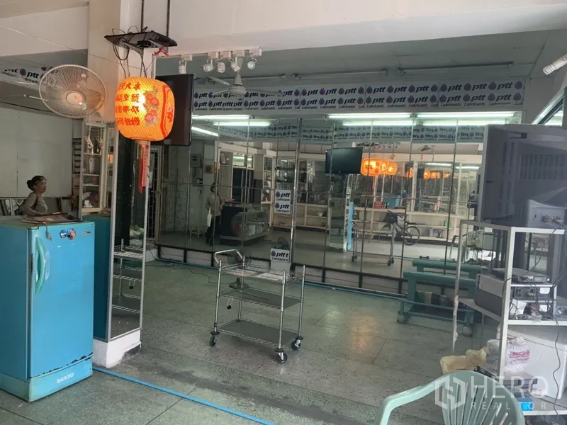Shophouse for rent in Khlong Toei, Bangkok - Open-plan space with full-length mirrors, ceiling lights and a movable metal rack, ideal for showroom use.