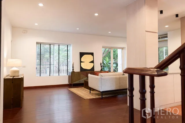 Detached House for rent in Watthana, Bangkok - Living area viewed from the staircase with wood floors and recessed lights.