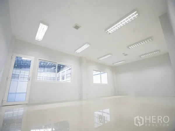 工厂 出租在Bang Bo, Samut Prakan - 明亮的办公室，白色墙面与瓷砖地面，荧光灯照明，窗户可眺望生产车间