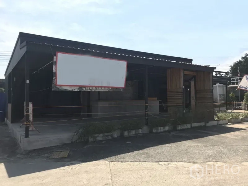 Retail Space for rent in Khlong Toei, Bangkok - Single-storey retail unit with steel roof, blank signboard frame and open forecourt near Phra Khanong.