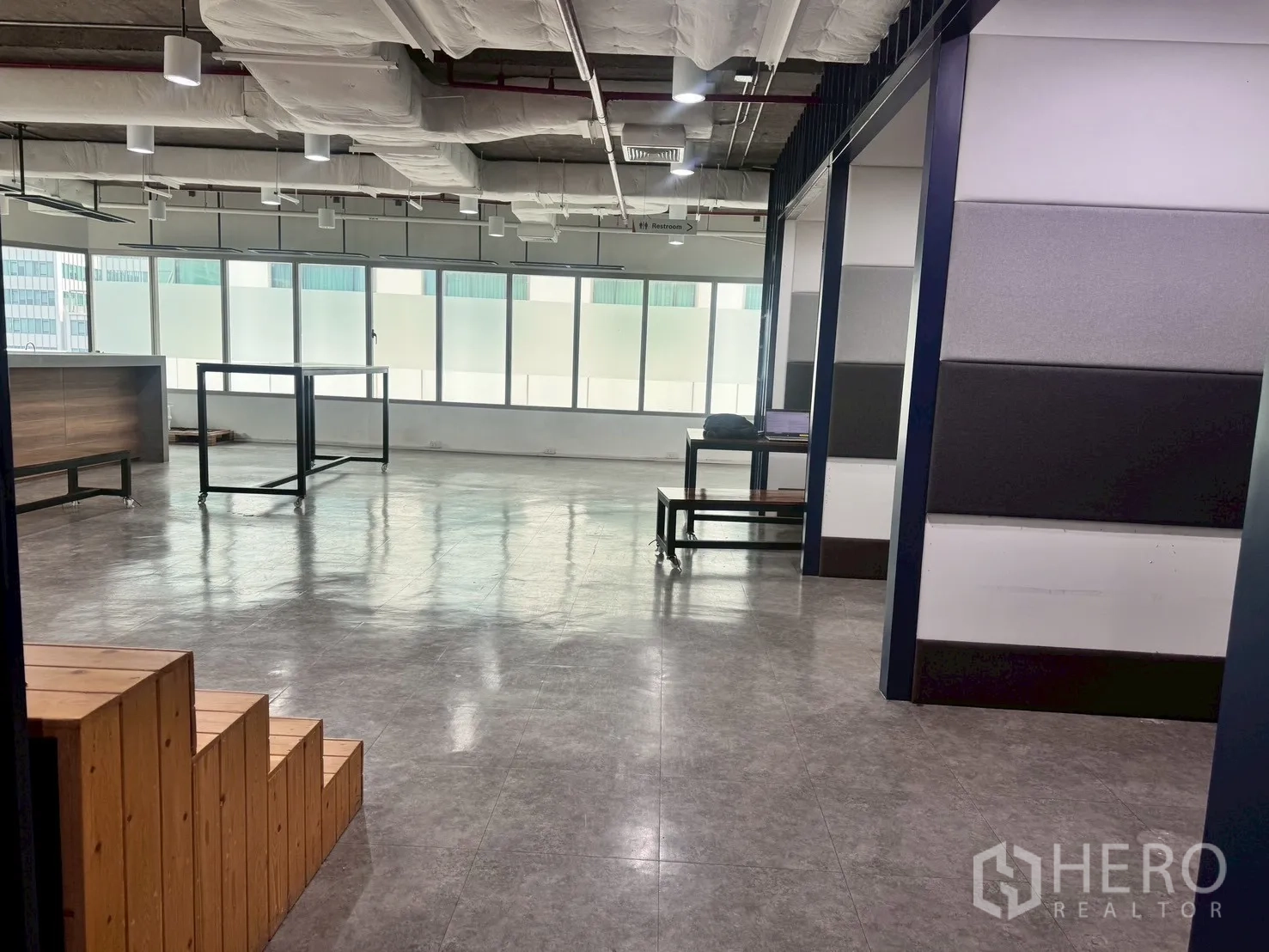 Office Space for rent in Watthana, Bangkok - Bright open-plan space with large windows, work tables and wall panels.
