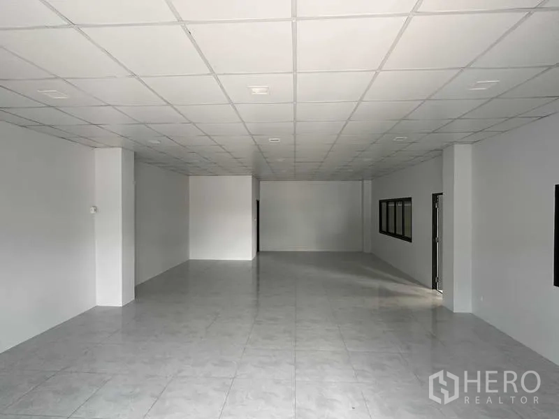 Warehouse for rent in Bang Phli, Samut Prakan - Airy office area with tiled floors, drop ceiling, and windows overlooking the warehouse.