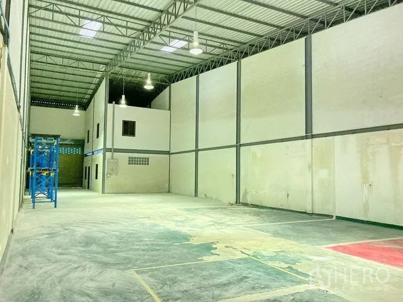 Factory for rent in Samut Prakan - Large factory hall with high clear height, steel roof, hanging lights and open production space.
