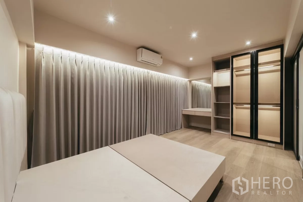 Townhouse for rent in Watthana, Bangkok - Bedroom with built-in wardrobe, dressing area and soft drapery.
