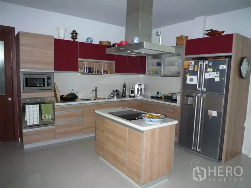 Detached House for rent in Khan Na Yao, Bangkok - Modern L-shaped kitchen with island, range hood, built-in oven and double-door fridge