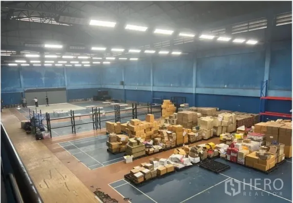 Warehouse for rent in Saphan Sung, Bangkok - High-ceiling warehouse interior with bright lighting and stacked parcels on open floor.